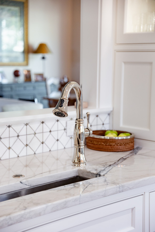 Inspiration for a mid-sized transitional galley medium tone wood floor eat-in kitchen remodel in Charleston with an undermount sink, beaded inset cabinets, white cabinets, quartzite countertops, white backsplash, mosaic tile backsplash, stainless steel appliances, a peninsula and white countertops