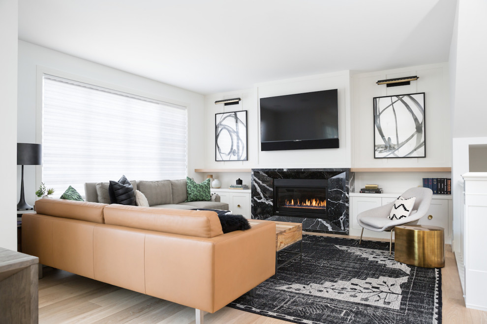 This is an example of a transitional open concept living room in Calgary with white walls, light hardwood floors, a standard fireplace, a stone fireplace surround and beige floor.