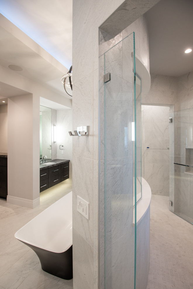 This is an example of a large modern master bathroom in Phoenix with flat-panel cabinets, black cabinets, a freestanding tub, an open shower, a one-piece toilet, white tile, slate, white walls, slate floors, a drop-in sink, granite benchtops, white floor, an open shower, multi-coloured benchtops, an enclosed toilet, a double vanity, a floating vanity and recessed.