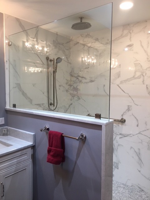 Design ideas for a large contemporary master bathroom in Philadelphia with flat-panel cabinets, white cabinets, an open shower, porcelain tile, porcelain floors, marble benchtops and an open shower.