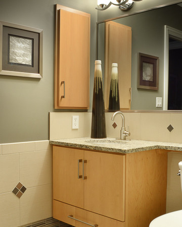 This is an example of a large transitional bathroom in Raleigh with a drop-in sink, flat-panel cabinets, light wood cabinets, granite benchtops, a one-piece toilet, beige tile, ceramic tile, grey walls and ceramic floors.