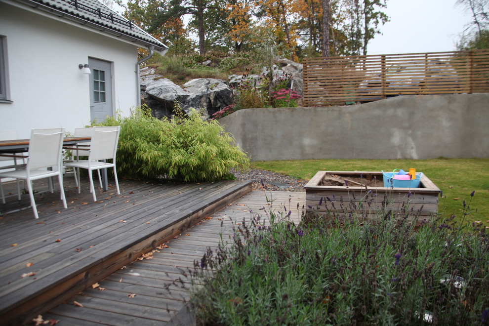 Inspiration for a sloped garden in Stockholm with a retaining wall.