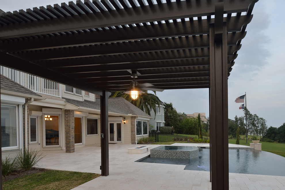 Large transitional backyard stone pool photo in Houston with a pergola