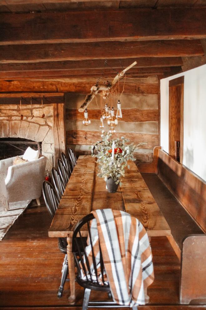 На фото: кухня-столовая в стиле кантри с темным паркетным полом, коричневым полом и балками на потолке с