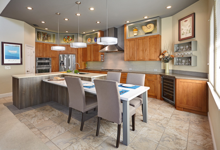 Inspiration for a mid-sized contemporary l-shaped eat-in kitchen in Sacramento with an undermount sink, shaker cabinets, light wood cabinets, solid surface benchtops, beige splashback, porcelain splashback, stainless steel appliances, travertine floors and with island.