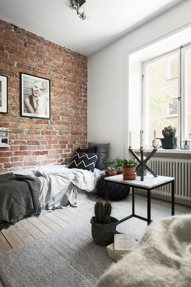 Mid-sized scandinavian guest bedroom in Stockholm with white walls and light hardwood floors.