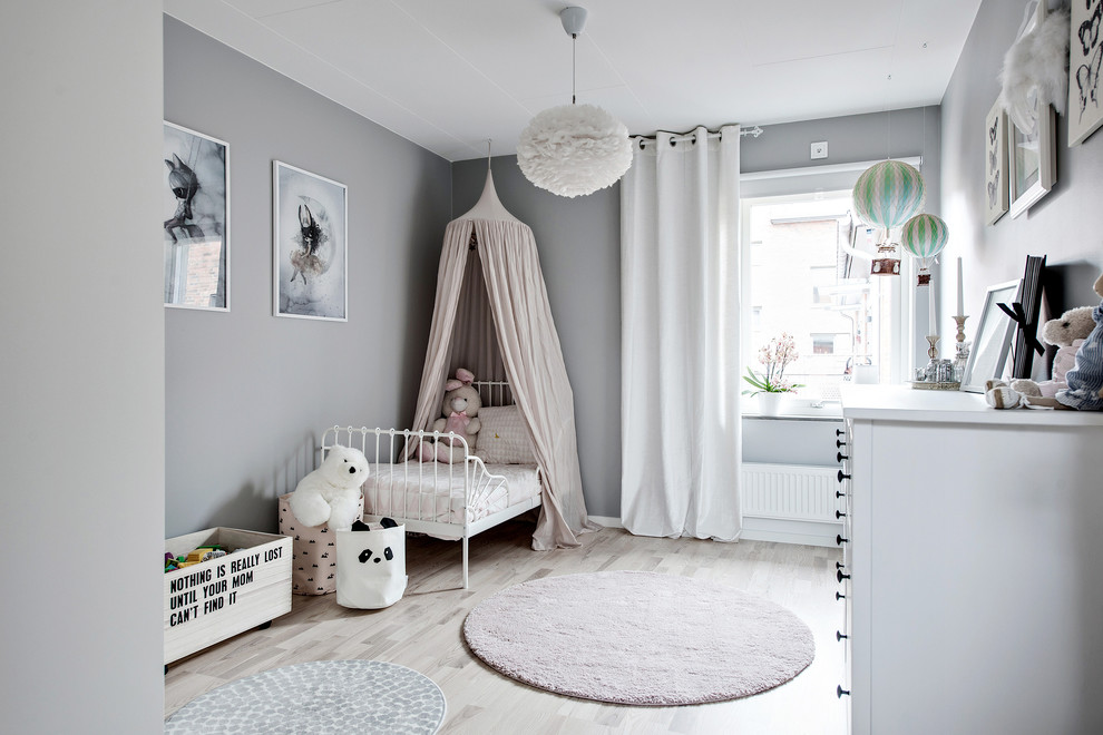 Design ideas for a mid-sized scandinavian kids' room for girls in Gothenburg with grey walls, light hardwood floors and beige floor.