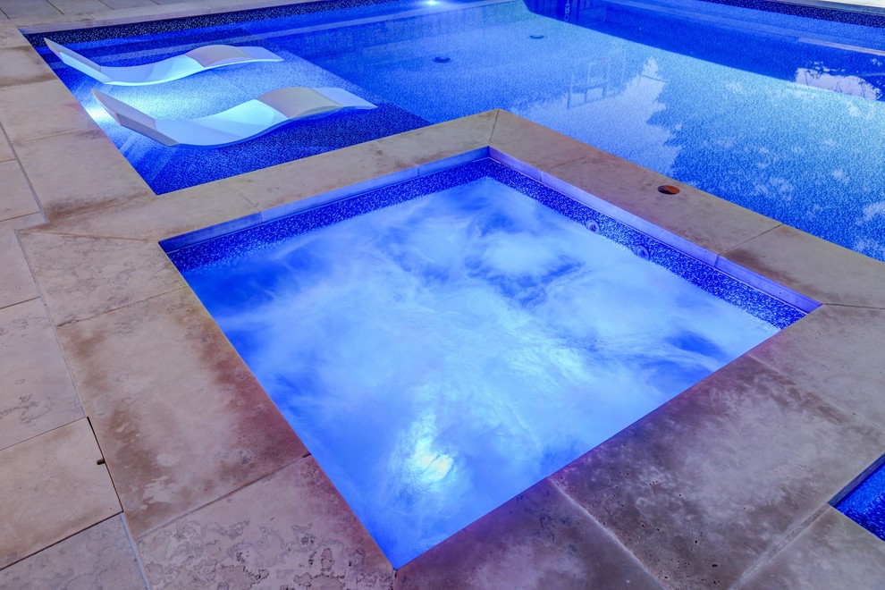 Inspiration for a mid-sized transitional backyard rectangular pool in Toronto with a hot tub and natural stone pavers.