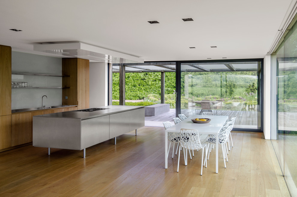Contemporary open plan dining in London with light hardwood floors.