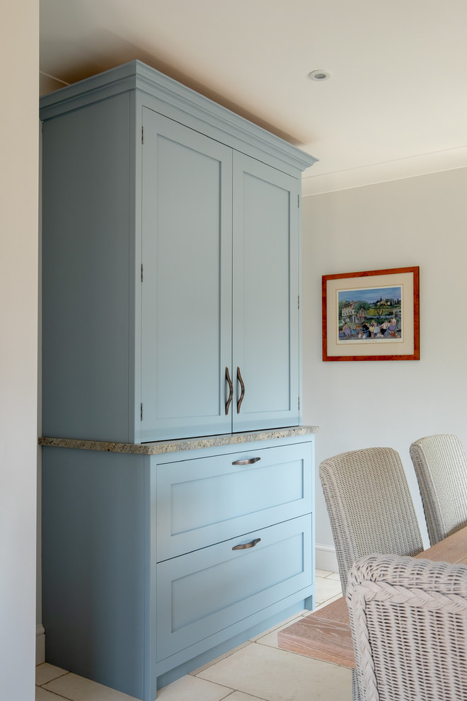 Inspiration for a mid-sized contemporary l-shaped separate kitchen in Hampshire with a farmhouse sink, shaker cabinets, blue cabinets, granite benchtops, multi-coloured splashback, stone slab splashback, black appliances, limestone floors, multi-coloured floor and multi-coloured benchtop.