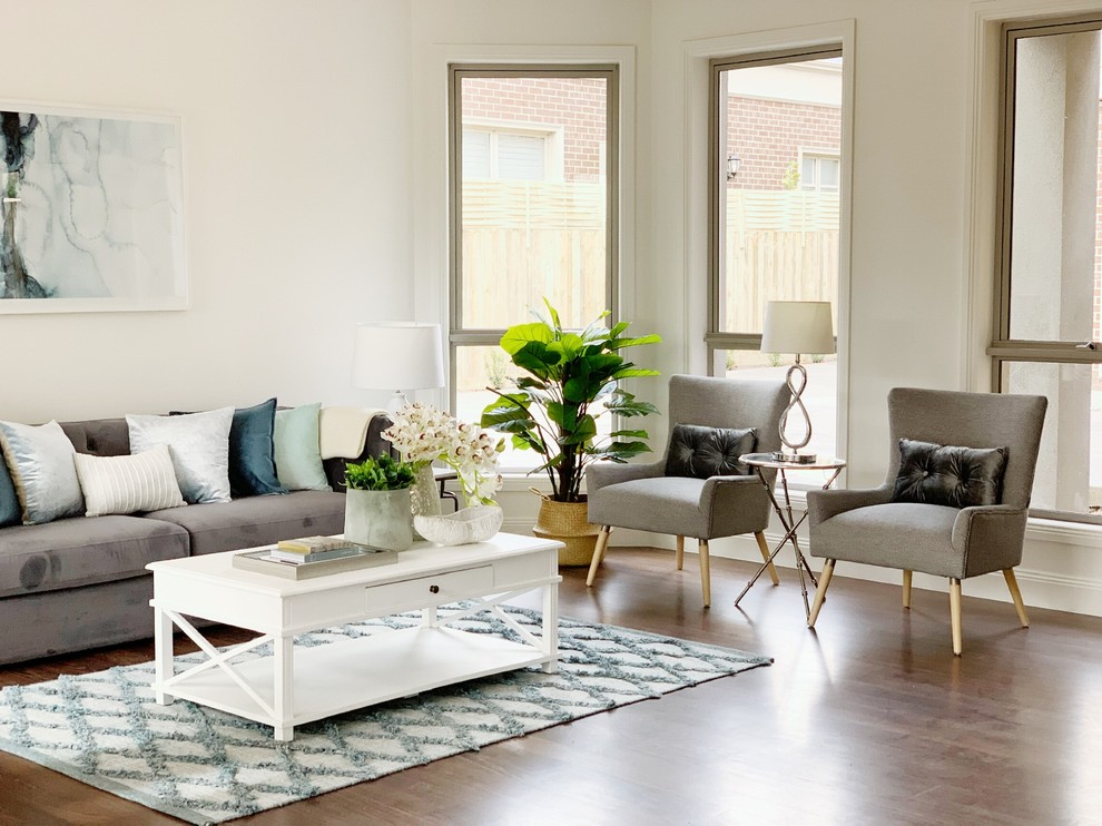 Design ideas for a transitional living room in Melbourne with white walls, medium hardwood floors and brown floor.