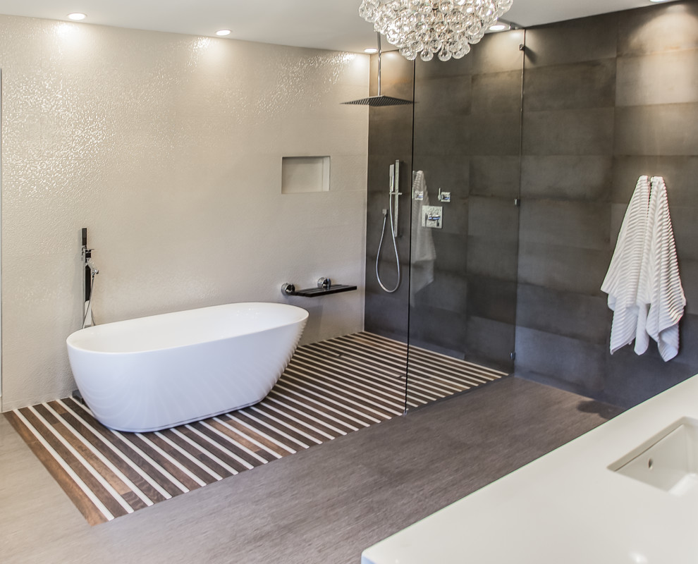 This is an example of an expansive contemporary master bathroom in Houston with an undermount sink, furniture-like cabinets, dark wood cabinets, quartzite benchtops, a freestanding tub, a shower/bathtub combo, a wall-mount toilet, gray tile, porcelain tile, multi-coloured walls and porcelain floors.