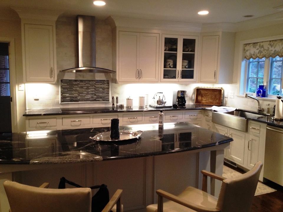 Inspiration for a large transitional l-shaped medium tone wood floor kitchen remodel with a farmhouse sink, beaded inset cabinets, white cabinets, white backsplash, subway tile backsplash, stainless steel appliances and an island