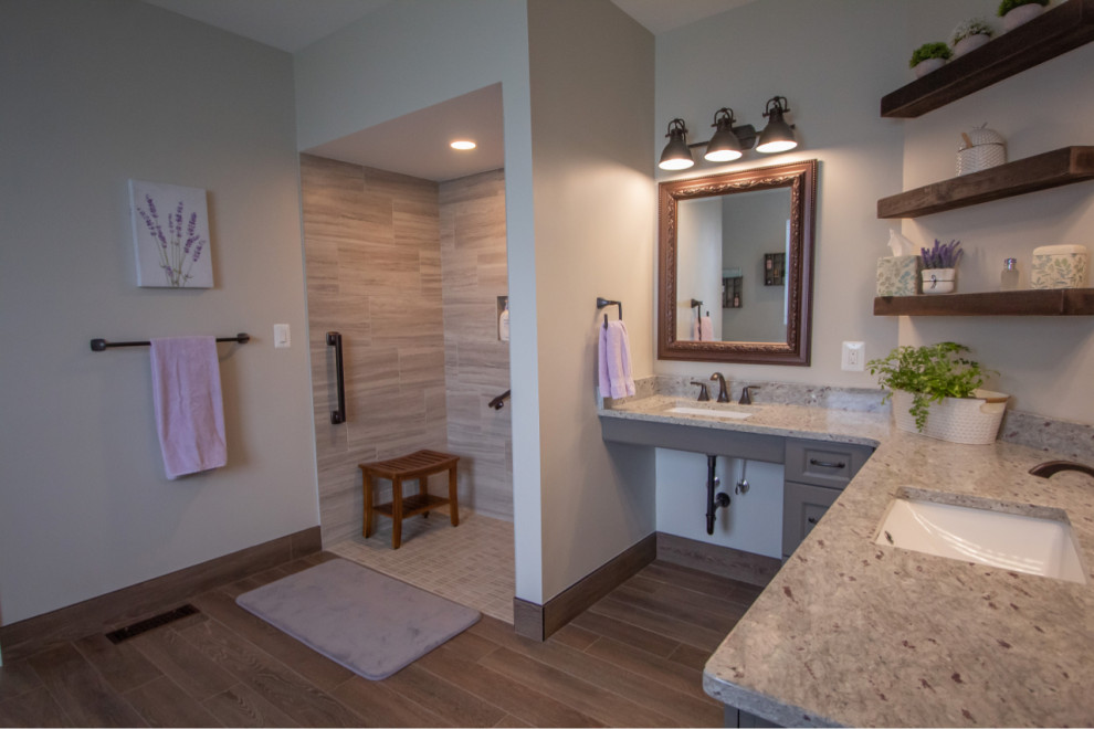 Klassisk inredning av ett stort grå grått en-suite badrum, med luckor med infälld panel, grå skåp, ett fristående badkar, en kantlös dusch, grå kakel, porslinskakel, grå väggar, klinkergolv i porslin, ett integrerad handfat, granitbänkskiva, grått golv och med dusch som är öppen