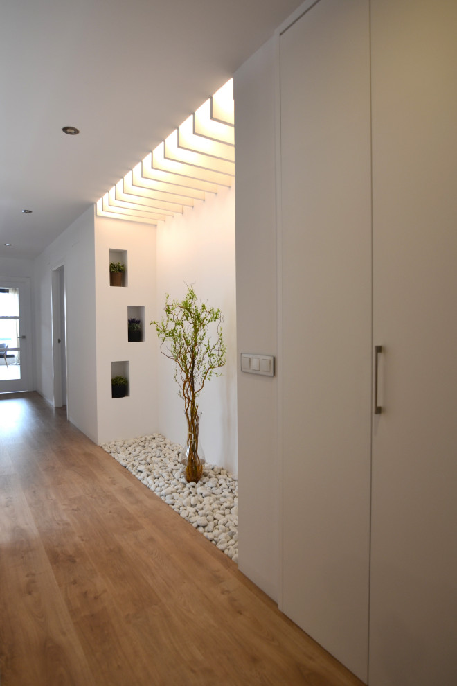Imagen de recibidores y pasillos escandinavos de tamaño medio con paredes blancas, suelo de madera en tonos medios y suelo marrón