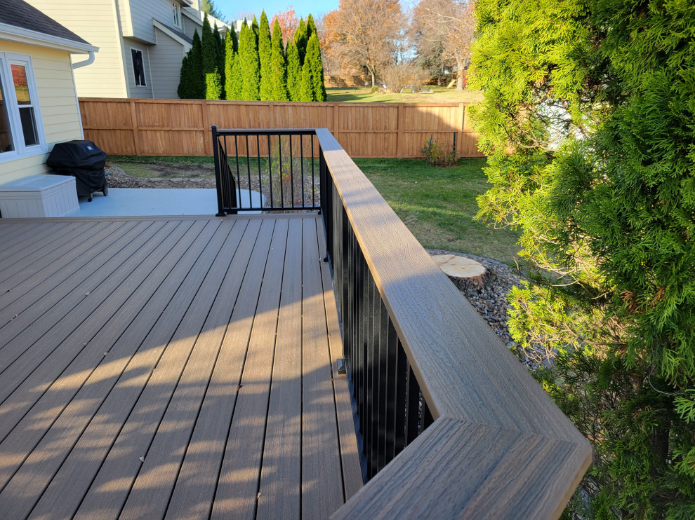 Deck - mid-sized backyard ground level privacy and metal railing deck idea with no cover
