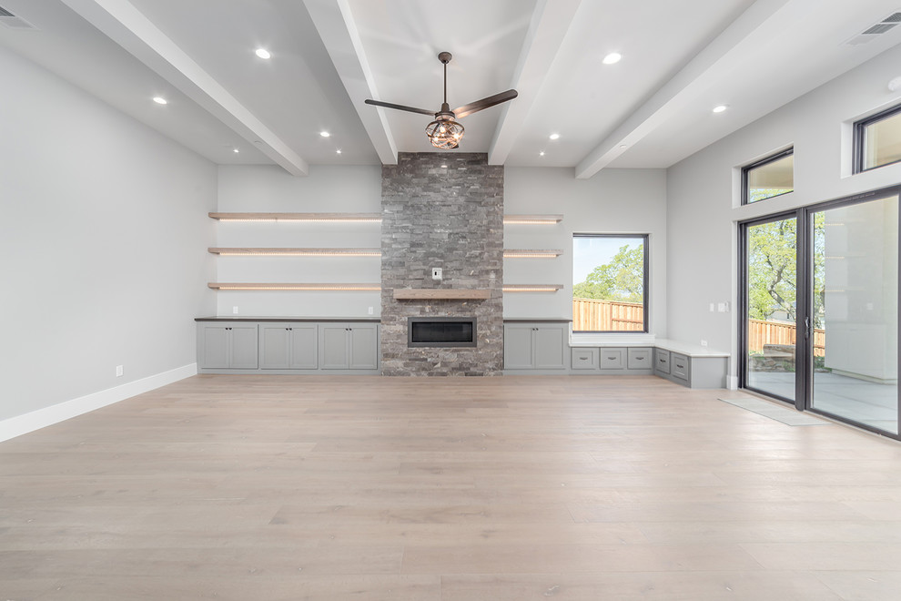 Large modern open concept family room in Sacramento with a music area, grey walls, light hardwood floors, a standard fireplace, a stone fireplace surround, a built-in media wall and beige floor.