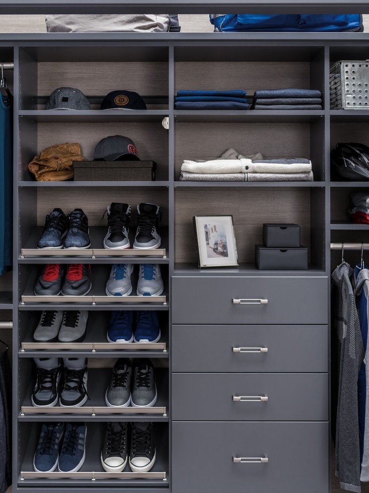 Design ideas for a mid-sized modern men's built-in wardrobe in Chicago with flat-panel cabinets, grey cabinets and grey floor.