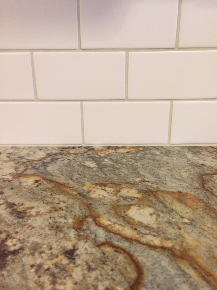 Inspiration for a rustic brown floor kitchen remodel in Cincinnati with a double-bowl sink, raised-panel cabinets, beige cabinets, granite countertops, white backsplash, terra-cotta backsplash and stainless steel appliances