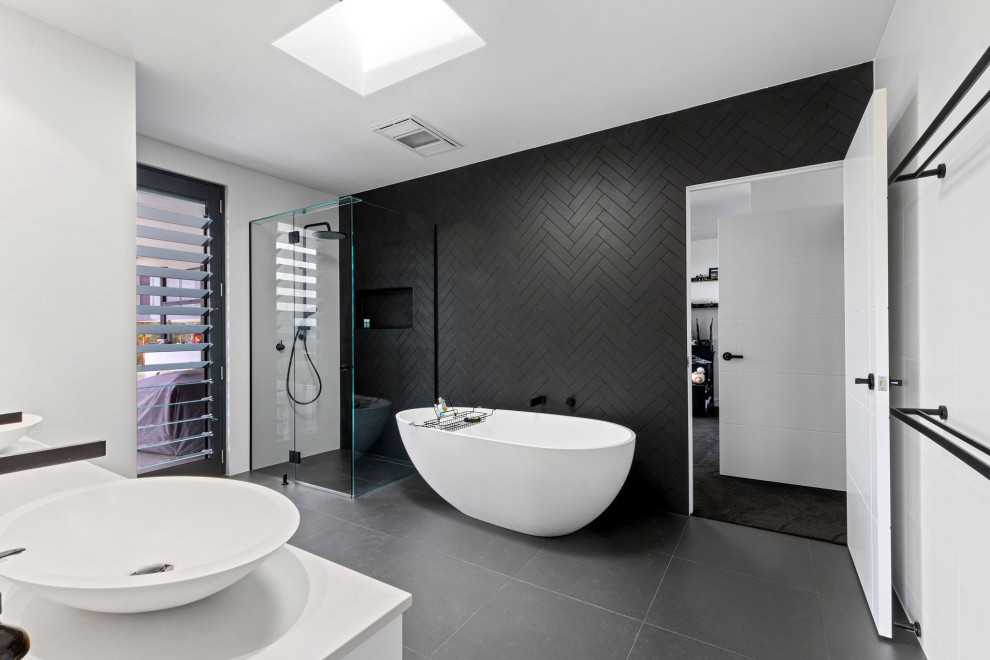 Large contemporary master bathroom in Sunshine Coast with white cabinets, a freestanding tub, black tile, a vessel sink, white benchtops, a corner shower, porcelain tile, white walls, porcelain floors, engineered quartz benchtops, black floor, a hinged shower door, a double vanity and a floating vanity.