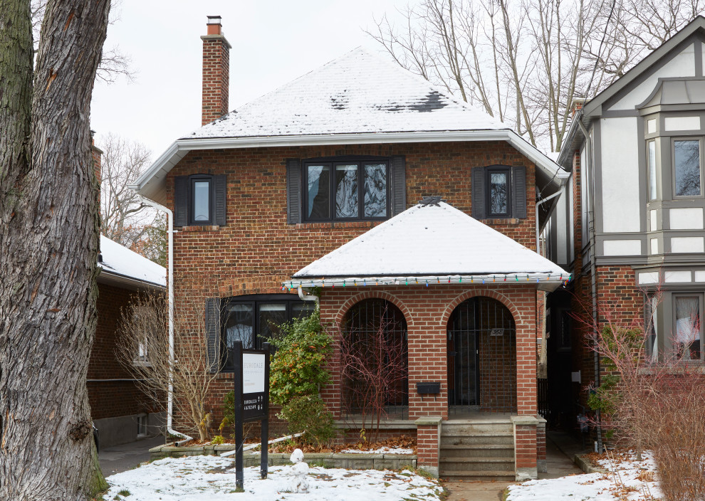Photo of a medium sized and red traditional two floor brick detached house in Toronto with a shingle roof and a black roof.