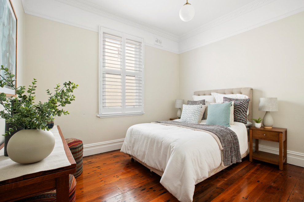Foto di una camera da letto minimal di medie dimensioni con pareti beige, pavimento in legno massello medio e pavimento marrone