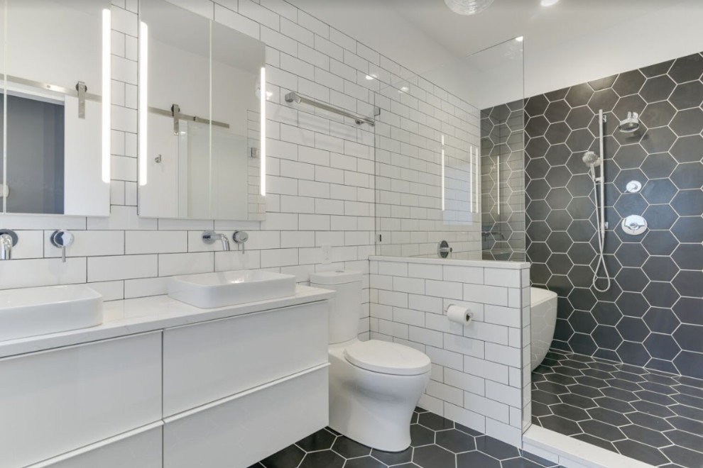 Mid-sized modern master wet room bathroom in Portland with flat-panel cabinets, white cabinets, a freestanding tub, a two-piece toilet, white tile, subway tile, white walls, porcelain floors, an undermount sink, engineered quartz benchtops, black floor, a hinged shower door and white benchtops.