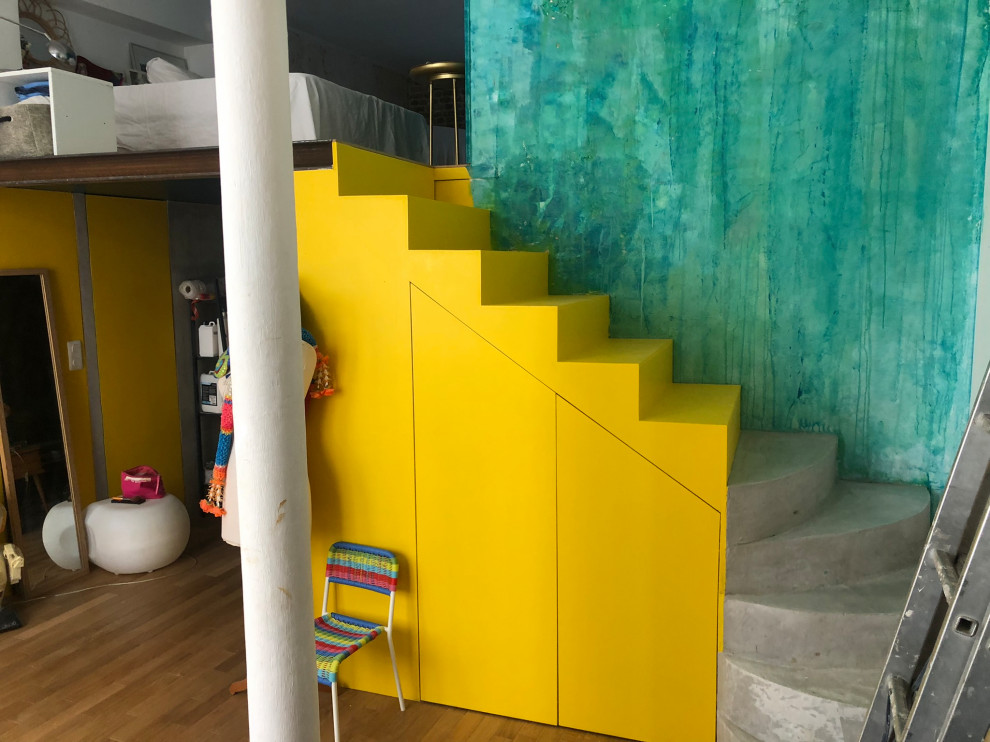Kleine Stilmix Treppe in L-Form mit gebeizten Holz-Treppenstufen und Beton-Setzstufen in Paris