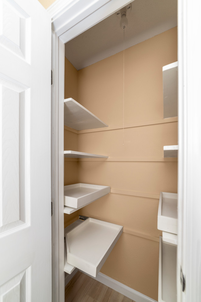 Small transitional built-in wardrobe in Houston with white cabinets, porcelain floors and beige floor.