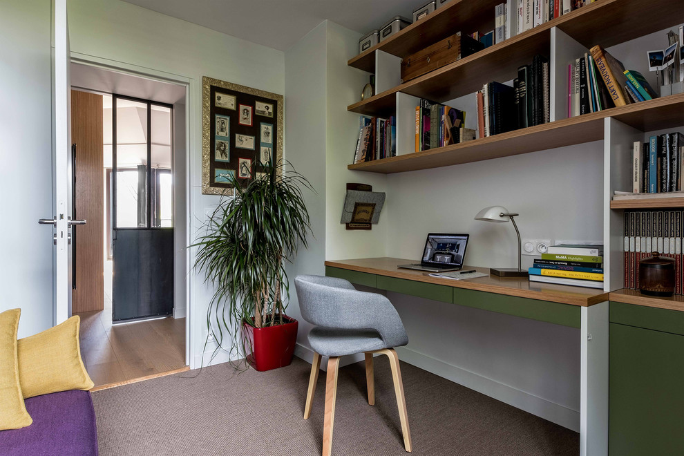 This is an example of an industrial home office in Paris with white walls, a built-in desk and white floor.