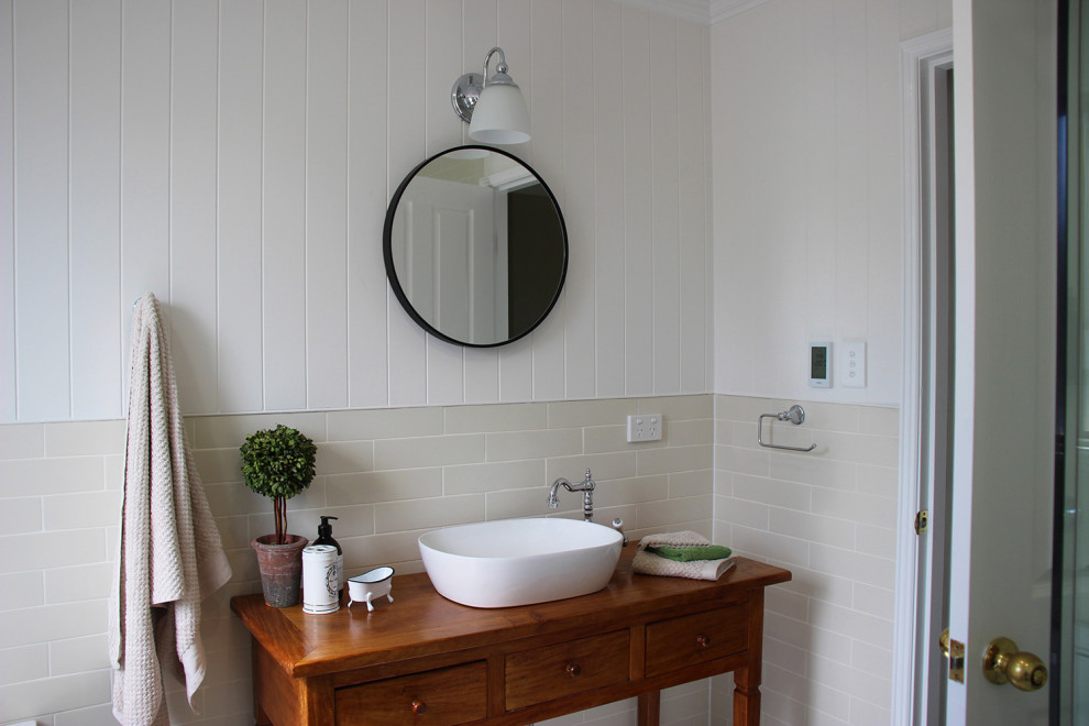 Exempel på ett mellanstort lantligt badrum, med skåp i mellenmörkt trä, ett hörnbadkar, en hörndusch, beige kakel, porslinskakel, mosaikgolv, ett fristående handfat och dusch med gångjärnsdörr