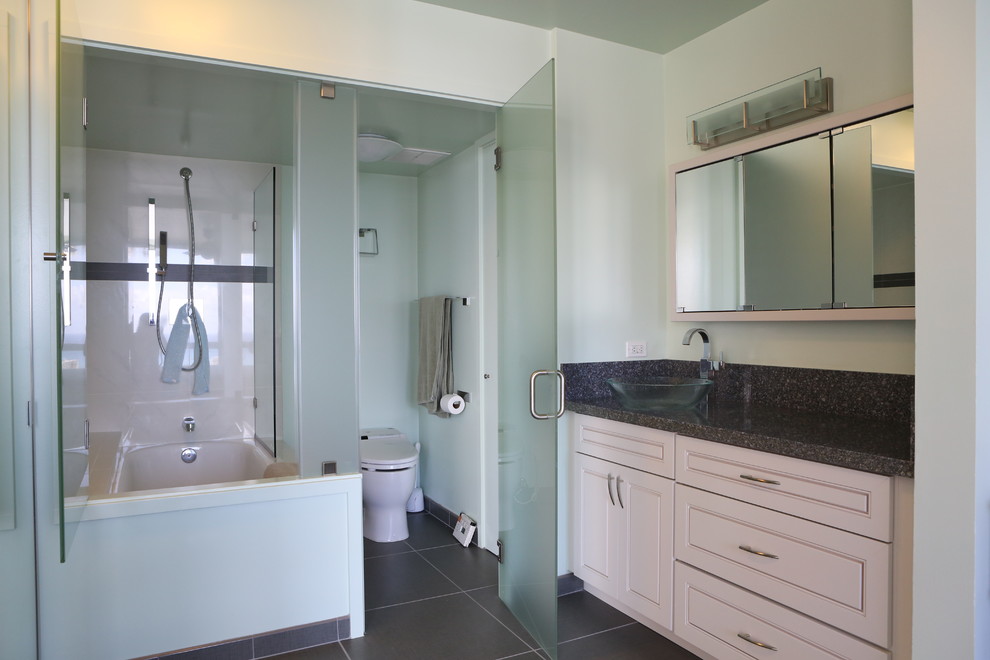 Photo of a mid-sized contemporary 3/4 bathroom in Hawaii with a drop-in sink, flat-panel cabinets, white cabinets, engineered quartz benchtops, a drop-in tub, a shower/bathtub combo, a bidet, gray tile, stone slab, green walls and ceramic floors.
