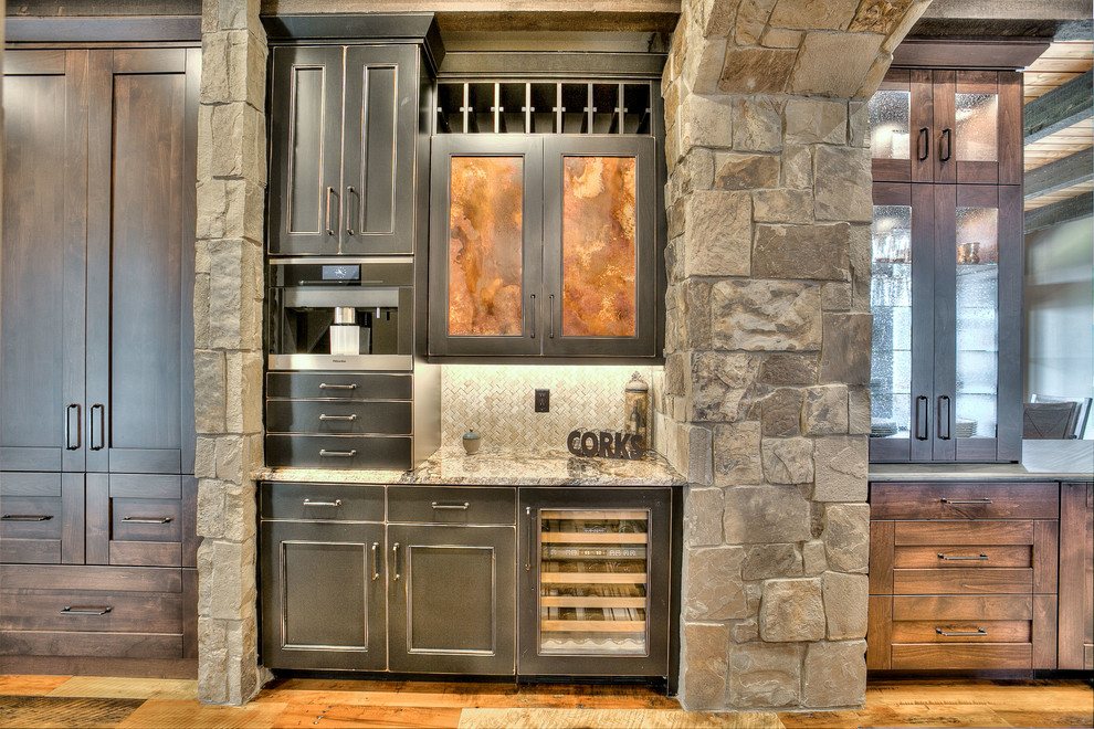 Inspiration for a huge rustic l-shaped medium tone wood floor eat-in kitchen remodel in Denver with an undermount sink, shaker cabinets, medium tone wood cabinets, granite countertops, beige backsplash, stone tile backsplash, stainless steel appliances and two islands