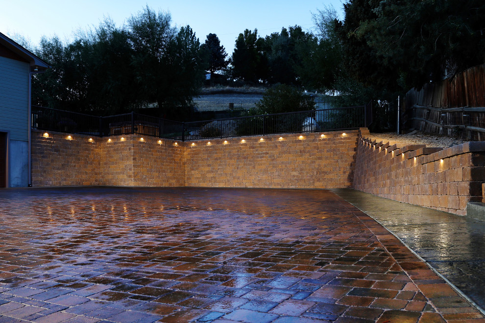Large traditional front yard full sun driveway in Boise with a retaining wall and brick pavers for winter.