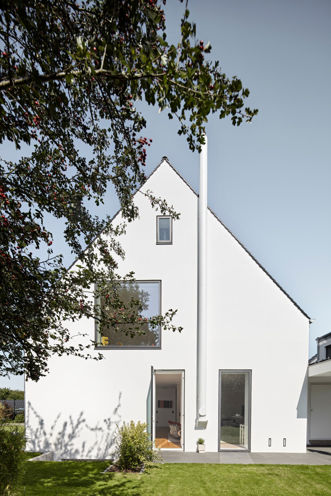 Dreistöckiges Skandinavisches Einfamilienhaus mit Putzfassade, weißer Fassadenfarbe und Satteldach in Köln