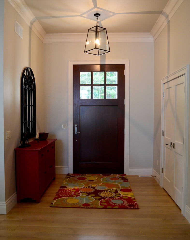 Design ideas for a beach style entryway in Other with grey walls, light hardwood floors, a single front door and a dark wood front door.