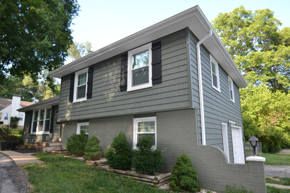 This is an example of a traditional split-level green exterior in Kansas City with vinyl siding.