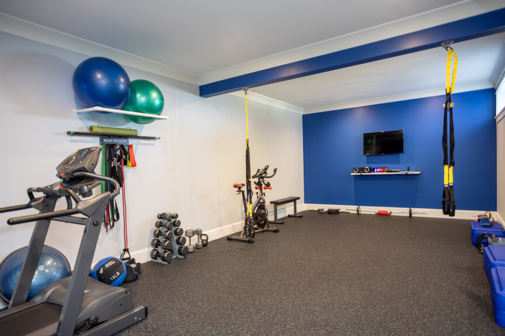 Multifunktionaler, Großer Klassischer Fitnessraum mit blauer Wandfarbe und grauem Boden in Sonstige