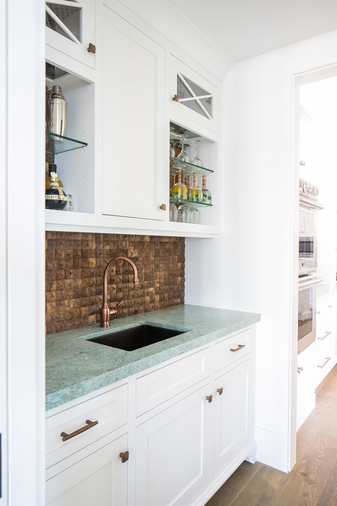 Photo of a small tropical single-wall wet bar in Orange County with an undermount sink, shaker cabinets, white cabinets, quartzite benchtops, brown splashback, medium hardwood floors, brown floor and turquoise benchtop.