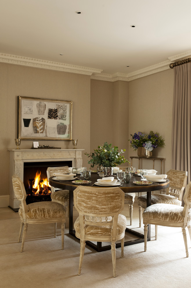 Photo of a traditional dining room in London with beige walls and a standard fireplace.