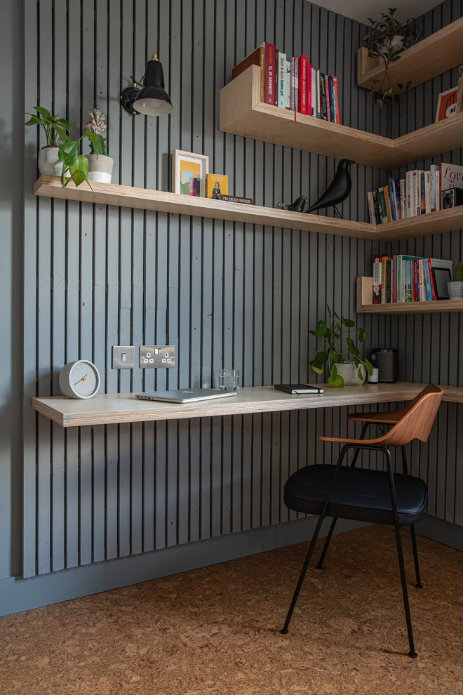 Ejemplo de despacho escandinavo de tamaño medio con paredes grises, suelo de corcho, escritorio empotrado, suelo marrón y panelado