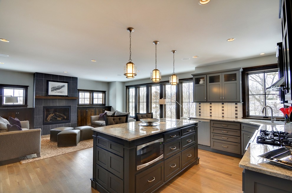 Traditional l-shaped open plan kitchen in Minneapolis with an undermount sink, recessed-panel cabinets, grey cabinets, multi-coloured splashback and stainless steel appliances.