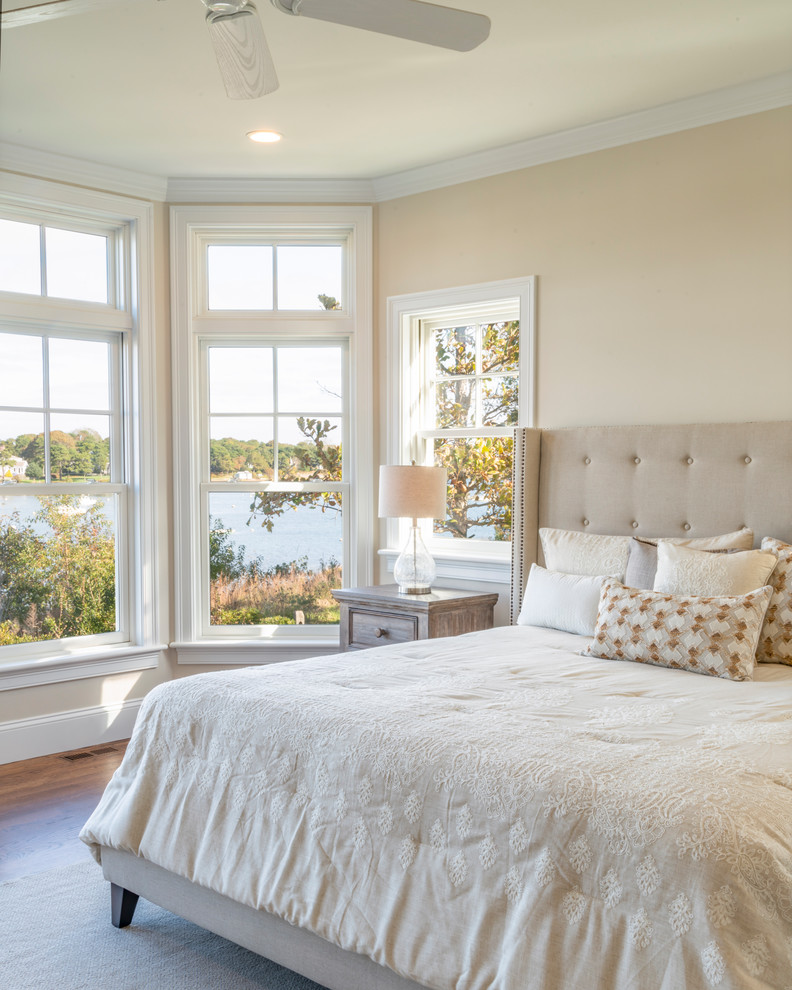 This is an example of a beach style master bedroom in Boston with beige walls.