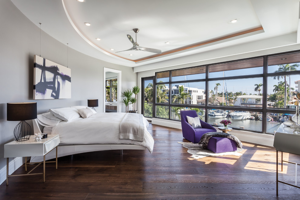 Photo of a contemporary master bedroom in Miami with grey walls, dark hardwood floors and brown floor.