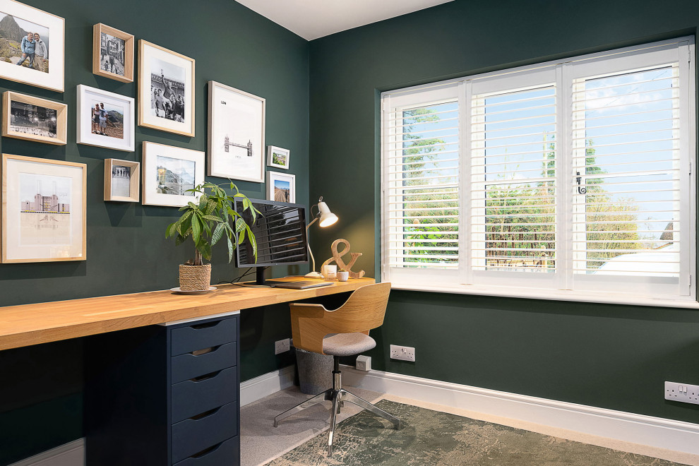 Ispirazione per un piccolo studio minimalista con pareti verdi, moquette, scrivania incassata e pavimento beige