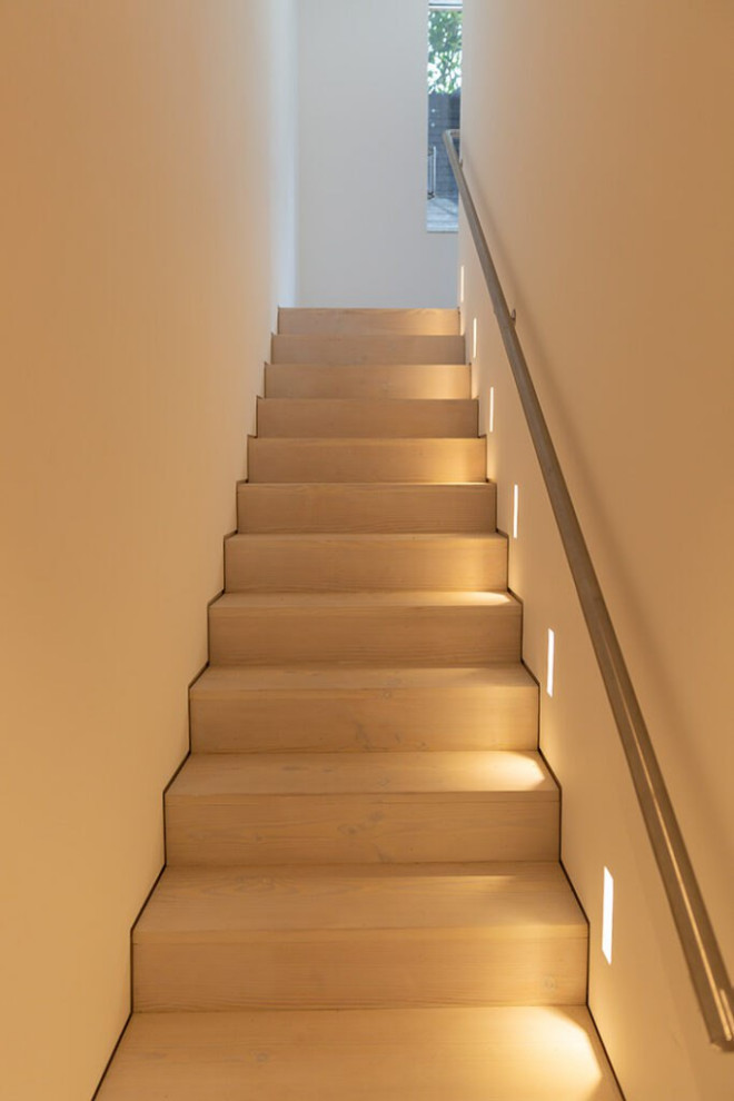 Réalisation d'un escalier droit nordique en béton de taille moyenne avec des contremarches en béton, un garde-corps en métal, boiseries et éclairage.