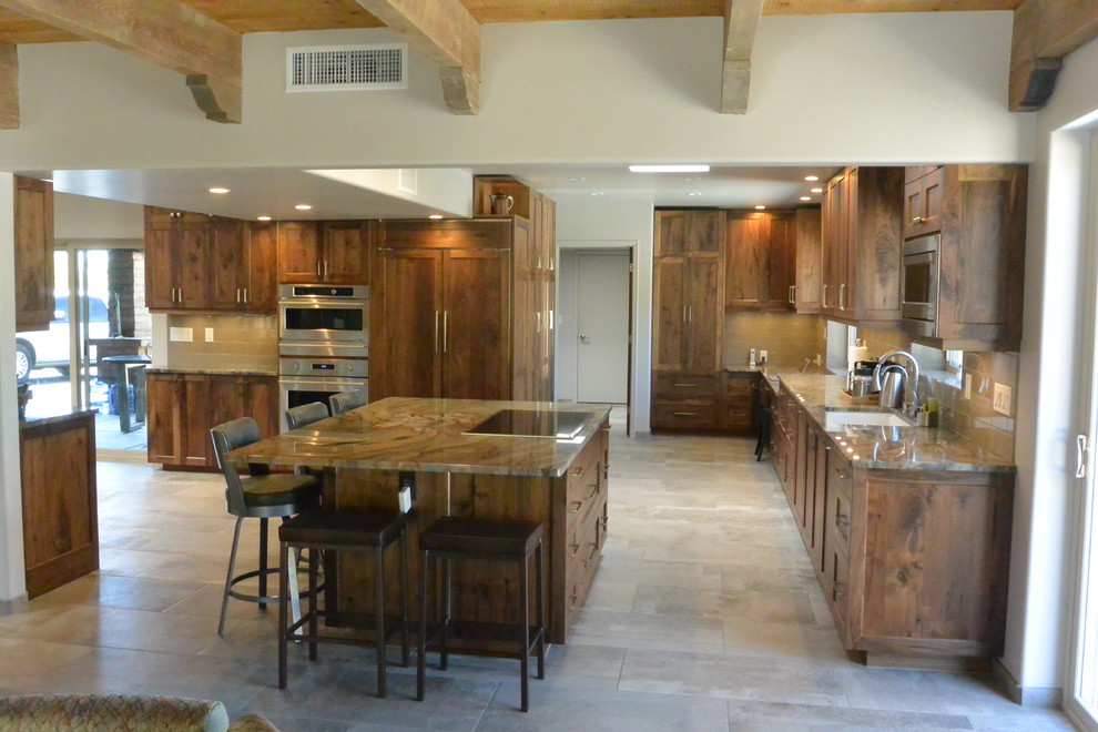 Open concept kitchen - huge transitional l-shaped porcelain tile and gray floor open concept kitchen idea with an undermount sink, shaker cabinets, medium tone wood cabinets, quartzite countertops, white backsplash, porcelain backsplash, paneled appliances, an island and green countertops