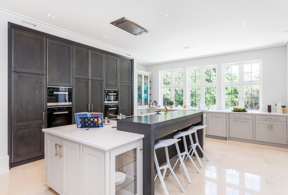 This is an example of a transitional kitchen in London with shaker cabinets and with island.