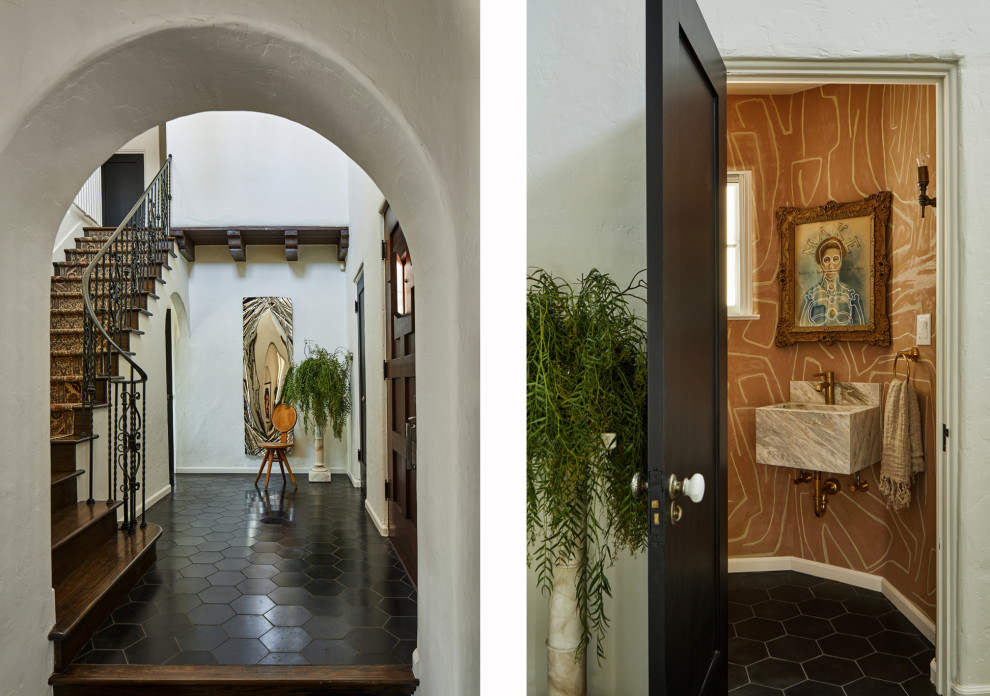 На фото: большая входная дверь в средиземноморском стиле с белыми стенами, полом из терракотовой плитки, одностворчатой входной дверью, входной дверью из темного дерева, черным полом, балками на потолке и обоями на стенах