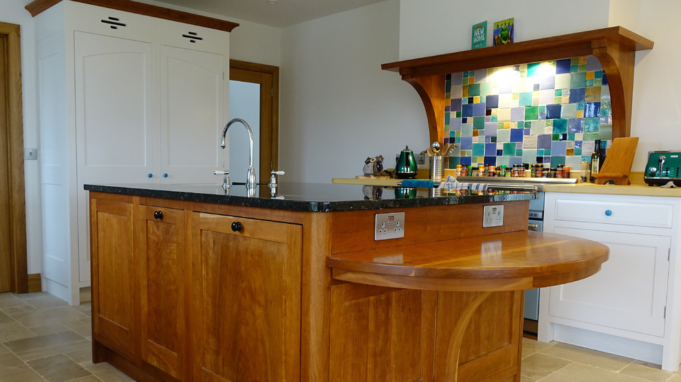 Medium sized traditional kitchen/diner in Other with a belfast sink, shaker cabinets, white cabinets, granite worktops, integrated appliances, limestone flooring and an island.